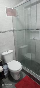 a bathroom with a toilet and a glass shower at Hotel Don Enrique in El Soberbio