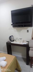 un salon avec une télévision sur une table dans l'établissement Hotel Don Enrique, à El Soberbio