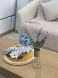 een tafel met een bord eten en flessen water bij Oceanhomes- Room love sick in Gia Lâm Pho