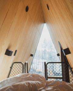 1 Schlafzimmer mit 2 Betten und einem großen Fenster in der Unterkunft PAN Treetop Cabins in Åsnes