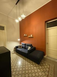 - un salon avec un canapé bleu et un mur rouge dans l'établissement Appartamento Vento D'Estate, à Bagheria