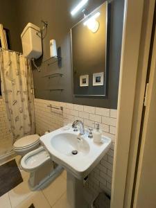 La salle de bains est pourvue d'un lavabo, de toilettes et d'un miroir. dans l'établissement Appartamento Vento D'Estate, à Bagheria