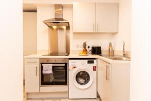 a kitchen with a washing machine and a sink at Cosy Retreat in the heart of Preston in Preston