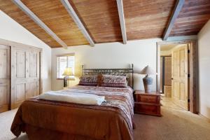 a bedroom with a large bed and wooden ceilings at Home in the Pines in Munds Park