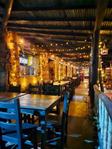 ロス・サントスにあるCabañas y Hostal Bonanza mesa de los santosの照明付きレストランのテーブルと椅子
