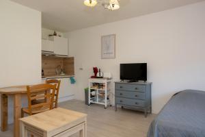 a bedroom with a bed and a table and a kitchen at Studio meublé in Aix-les-Bains