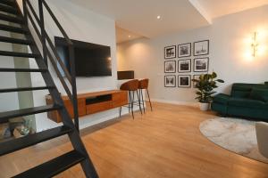 a living room with a green couch and a television at Duplex Near Paris/ RER 4 bedrooms 100m2 Balcony in Meudon