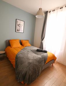 a bedroom with a bed with orange pillows at Duplex Near Paris/ RER 4 bedrooms 100m2 Balcony in Meudon