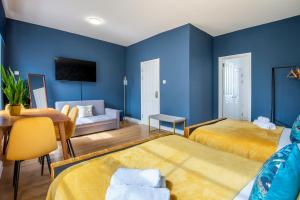 um quarto azul com 2 camas e um sofá em BRAND NEW The Palms: Luxury Family Residence em Londres