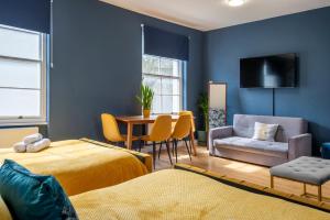 Habitación con 2 camas, mesa y silla en BRAND NEW The Palms: Luxury Family Residence, en Londres