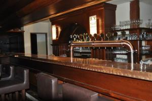 a bar with a wooden counter with a pipe at Pivovar Sandorf in Prievaly
