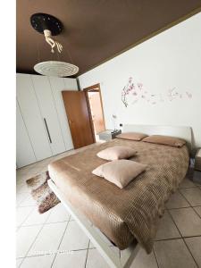 una camera da letto con un grande letto con cuscini sopra di ZARA HOUSE - Lake and Pet Friendly a Brusimpiano