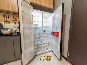 a white refrigerator with its doors open in a kitchen at Stylish Apartment and Cozy Feel in Kuching
