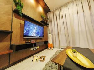 ein Wohnzimmer mit einem Flachbild-TV und einem Tisch in der Unterkunft Stylish Apartment and Cozy Feel in Kuching