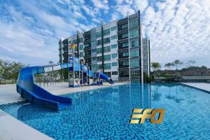 a swimming pool with a slide in front of a building at Stylish Apartment and Cozy Feel in Kuching