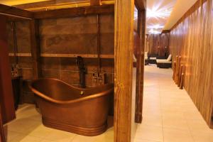 a bathroom with a wooden tub in a room at Pivovar Sandorf in Prievaly