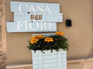 a white wooden crate with a sign and orange flowers at B&B Casa Fiore in Polignano a Mare