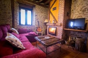 a living room with a couch and a fireplace at Casa Rural Inma, Segovia ,Hoces del Duraton y cerca de Madrid in Muñoveros
