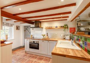 a large kitchen with white cabinets and a sink at Fiddler's Cottage in Montgomery