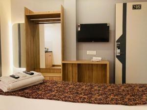 - une chambre avec un lit, une télévision et un miroir dans l'établissement The Lavish Stay, à Varanasi