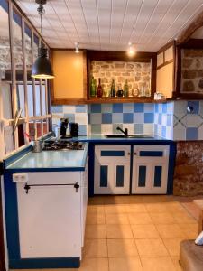 appartement L'Atelier in Isches في Isches: مطبخ بقمة الازرق والابيض