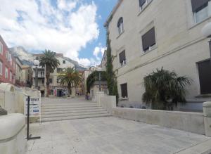 a city street with some buildings and palm trees at Apartment Adriatic in Makarska
