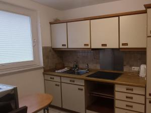a kitchen with white cabinets and a sink and a window at Felsen-Eck Apartments in Helgoland