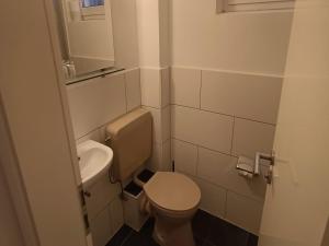 a small bathroom with a toilet and a sink at Felsen-Eck Apartments in Helgoland