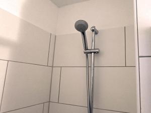 a shower with a shower head in a bathroom at Felsen-Eck Apartments in Helgoland