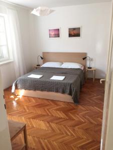 a bedroom with a bed and a wooden floor at Apartment Adriatic in Makarska