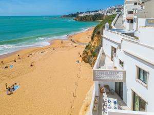 a view of a beach from a building at Casa na Muralha - Beach front - Rooftop Jacuzzi by DreamvillasAlbufeira in Albufeira