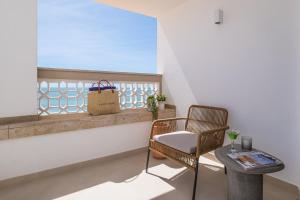a balcony with a table and a chair and a window at Casa na Muralha - Beach front - Rooftop Jacuzzi by DreamvillasAlbufeira in Albufeira