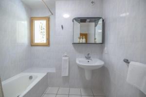 a white bathroom with a sink and a bath tub at Auberge du pont de l'Abîme in Gruffy