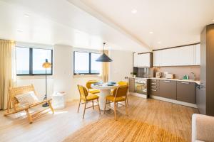 a kitchen and living room with a table and chairs at Casa na Muralha - Beach front - Rooftop Jacuzzi by DreamvillasAlbufeira in Albufeira