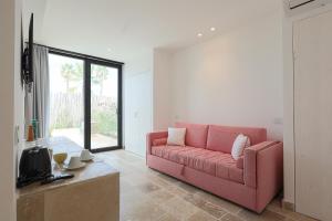 ein Wohnzimmer mit einem rosa Sofa und einem Tisch in der Unterkunft Valerio Resort beach club in Margherita di Savoia