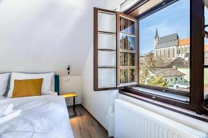 a bedroom with a bed and a window at Villa Wurmfeld in Český Krumlov