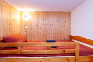 a wooden bed in a room with a wooden wall at Les Marmottes in Selonnet