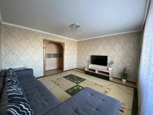 un soggiorno con divano e TV di 4-х комнатная квартира в центра города Астана a Astana
