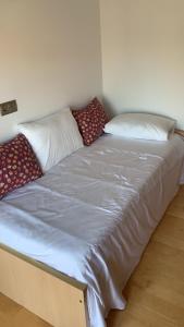 uma cama com almofadas num quarto em Amplio y cómodo piso en vilariño em Vilariño