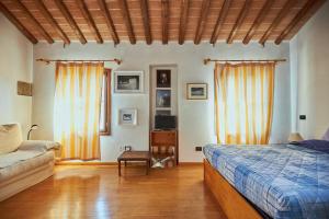 um quarto com uma cama e um sofá em Mansarda - Bassano Dieda em Bassano del Grappa
