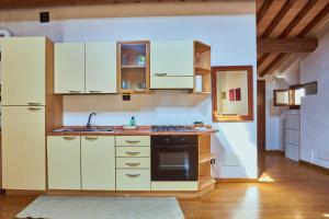 a kitchen with white cabinets and a sink at Mansarda - Bassano Dieda in Bassano del Grappa