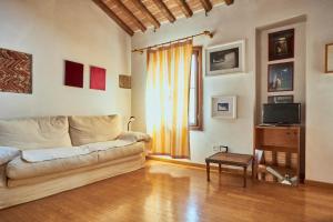 a living room with a couch and a television at Mansarda - Bassano Dieda in Bassano del Grappa