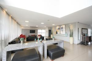 a living room with two tables and a couch at Colonial Flat Hotel in Itapetininga