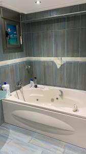 uma banheira branca na casa de banho com um espelho em Amplio y cómodo piso en vilariño em Vilariño