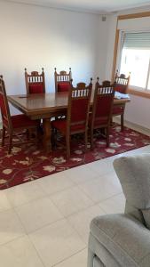 uma sala de jantar com uma mesa de madeira e cadeiras em Amplio y cómodo piso en vilariño em Vilariño