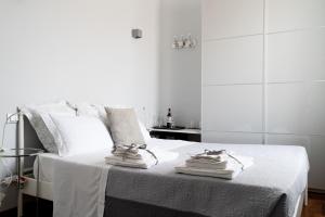 a white bedroom with a bed with towels on it at Central View Boutique in Florence