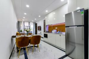 a kitchen with a table and chairs and a refrigerator at Aura Apartment Da Lat in Da Lat