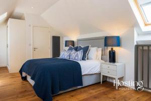 a bedroom with a bed with blue and white pillows at The Evergreen Courtyard Henley-On-Thames in Henley on Thames