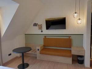 a room with a bed with a tv and a stool at Altes Bräuhaus in Gaildorf