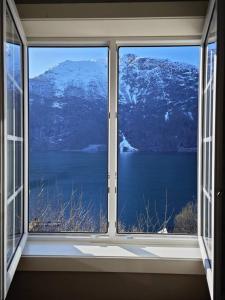 a window with a view of a snowy mountain at Rekkehus Tyssedal Trolltunga in Tveit